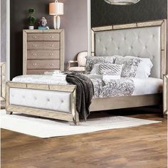 a bedroom with a bed, dressers and mirror in it's center area