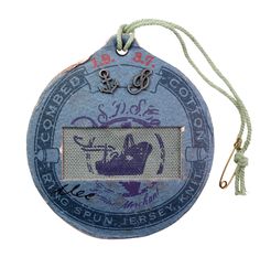 a badge with an anchor on it is hanging from a string