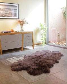 an animal skin rug on the floor next to a dresser