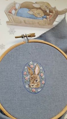 a close up of a cross stitch with a rabbit on it's face in the hoop