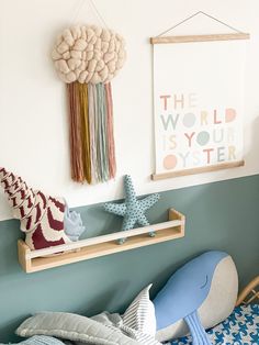 a child's bedroom with toys on the shelf and wall hangings above it