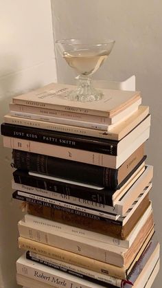 a stack of books sitting next to a glass filled with liquid