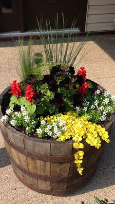 a wooden barrel filled with lots of flowers