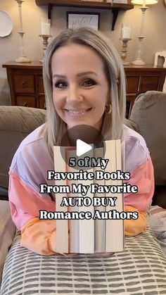 a woman sitting on top of a couch with a book in front of her face