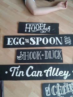 three signs on the floor that say egg spoon, shock duck and tin can alley