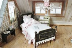 a dollhouse bedroom with a bed, dresser and chandelier in the corner