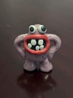 an odd looking toy on a table with its mouth wide open and eyes wide open