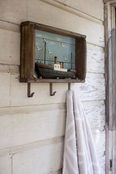 there is a towel hanging on the wall next to a shelf with a boat in it