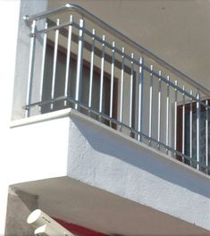 a white building with a metal balcony and balconies