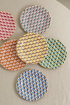 four colorful plates sitting on top of a table