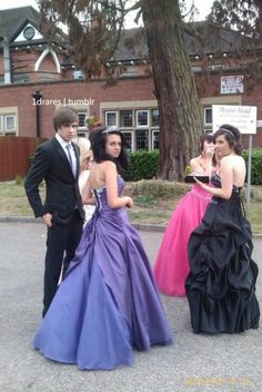 four young people dressed in formal wear standing next to each other on a street corner