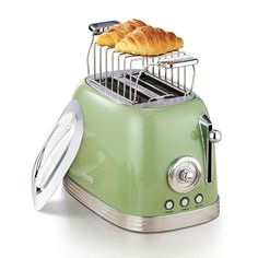 two croissants sitting on top of a toaster with bread in it