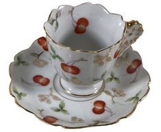 a cup and saucer with fruit designs on it