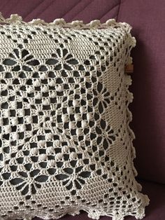 a crocheted pillow sitting on top of a purple couch