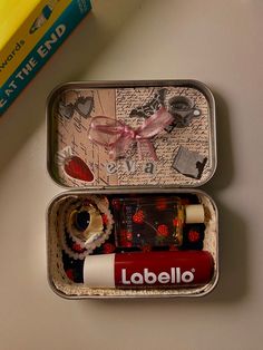 two tins filled with assorted items on top of a table