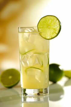 a glass filled with ice and lime slices