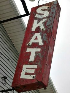 a red sign hanging from the side of a building that says skat on it