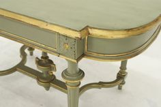 an old green table with gold trimmings on the top and bottom edge, sitting against a white background