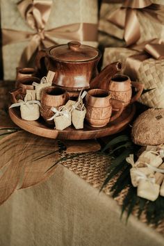 a wooden tray topped with pots and pans next to wrapped gift wrapping on top of a table