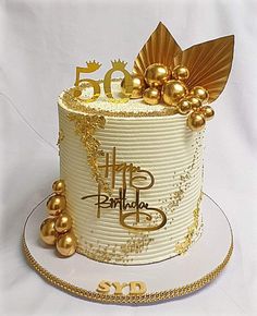 a white cake with gold decorations on top and the number fifty five on it's side