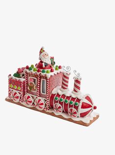 a santa clause riding on top of a red and white train with candy canes