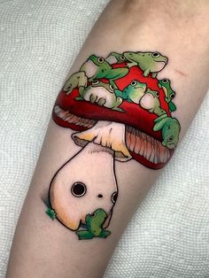 an arm with a mushroom and frogs on it