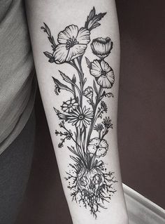 a black and white flower tattoo on the right arm, with flowers in it's center