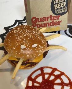 a cheeseburger with fries on a plate next to a box of beer