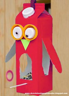 a red birdhouse with googly eyes on it's face and beaks