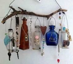 there are many different items hanging on the wall and in glass bottles with chains attached to them