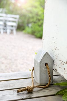 a concrete birdhouse tied to a wooden deck