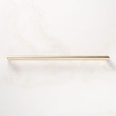 a gold colored metal handle on a white wall with a marble pattern in the background