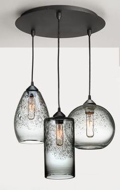 three glass lights hanging from a ceiling fixture