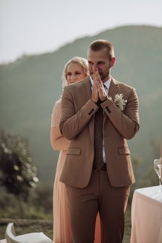 a man and woman standing next to each other in front of a table with food on it