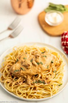 a white plate topped with spaghetti covered in gravy