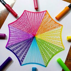 an umbrella made out of colored crayons on top of white paper with markers