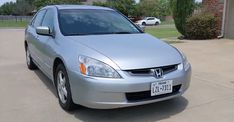 a silver honda accord is parked in a driveway