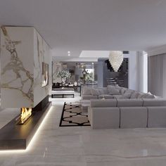 a living room with white furniture and a fire place in the middle of the room