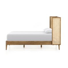 a bed with a wooden frame and white sheets