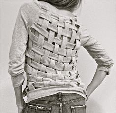 a woman with her back to the camera wearing jeans and a gray shirt that has holes in it