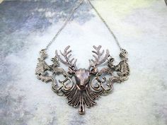 "Beautiful vintage style deer head necklace in antique silver tone with details throughout.  The necklace is collar bib style, a great statement piece.  It is a perfect gift for deer lover and it is an ideal gift for the holidays.  It can be worn dress up on a renaissance costume or just wear it with a casual everyday outfit.  It is also a suitable gift for a cosplayer. Measurement: metal pendant approx. 4.25\" x 3.25\"  necklace length approx. 18\" plus 2\" extension chain Material: Metal To view my other gift ideas available, please visit my shop: https://www.etsy.com/shop/theweddingjewelry Thank you for stopping by and happy shopping" Deer Head Necklace, Asymmetrical Jewelry, Deer Necklace, Sand Dollar Necklace, Deer Gifts, Red Topaz, Deer Animal, Bridal Statement Earrings, Floral Statement Necklace