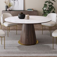 a dining room table with white chairs and a black vase on the top, in front of a beige wall