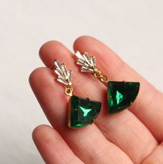 These great earrings are brass and feature a graduated art deco design. The tiny cubic zirconia jewels are cut into perfect rectangles. They remind us of classic Deco architecture, like the Chrysler building! The classically cut fan shaped stone is also glass in a beautiful, rich emerald green shade. The earrings measure 40mm (an inch and a half) in length and have gold plated ear wires. The emerald fan stone is designed to hang just below the earlobe. This piece of handmade jewellery comes pack Art Deco Emerald, Deco Architecture, Oval Locket, Chrysler Building, Earrings Art, Photo Locket, Green Opal, Art Deco Earrings, Green Diamond