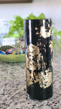 a black and gold vase sitting on top of a counter