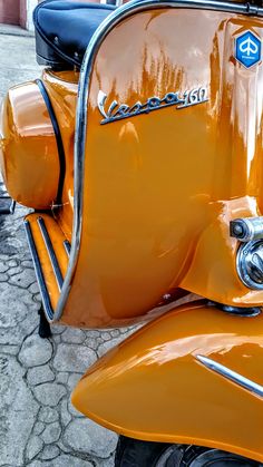 an orange scooter is parked on the street