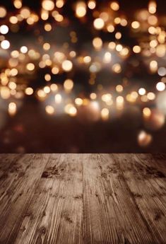 an empty wooden table with blurry lights in the background