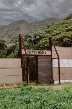 a sign that is on the side of a building with mountains in the back ground