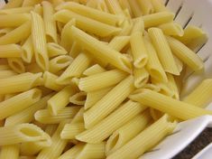 a white bowl filled with pasta on top of a counter