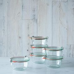 four glass containers with lids on a table