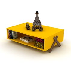 a yellow coffee table with some books on it and a vase sitting on top of it